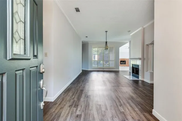 a view of a hallway with wooden floor and a kitchen