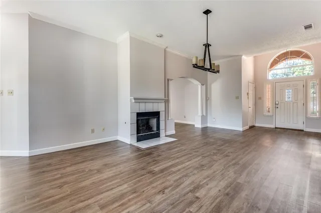a view of a room with wooden floor fireplace and window