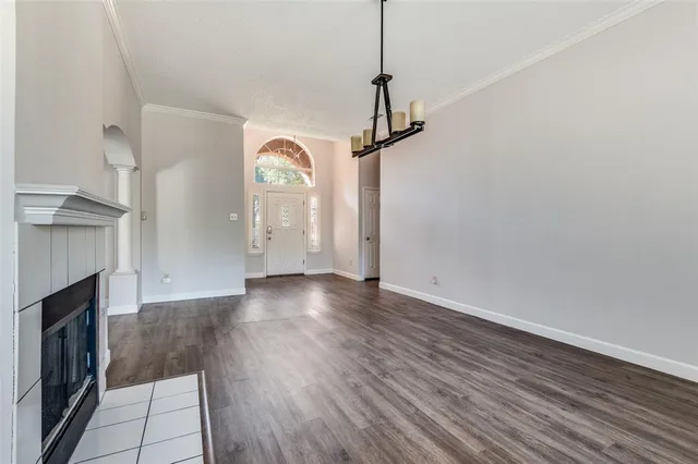 a view of empty room with wooden floor and fireplace