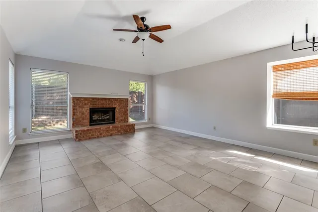 a view of empty room with fireplace and fan