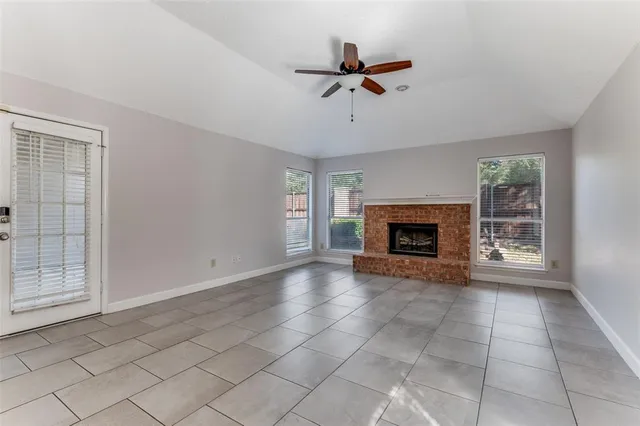 a view of an empty room with a fireplace and a window