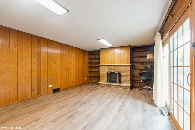 a view of an empty room with a fireplace and a window