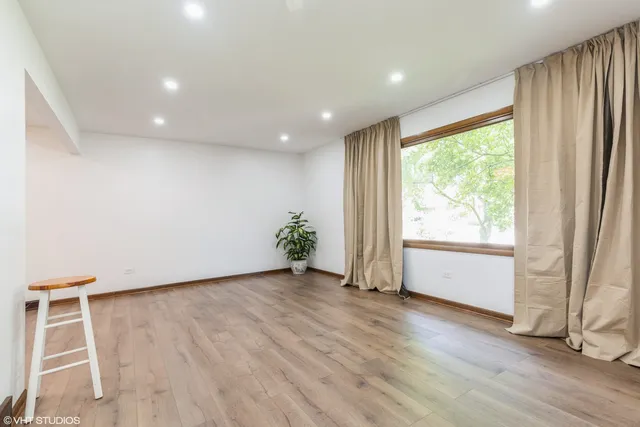 an empty room with wooden floor and a window