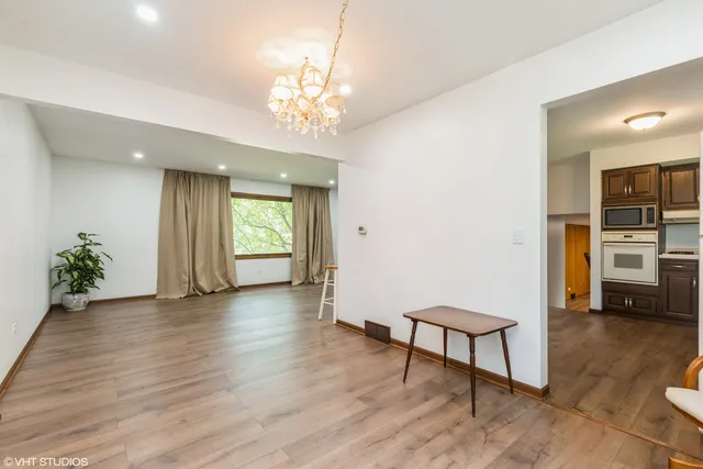 a view of a livingroom with furniture a chandelier and wooden floor
