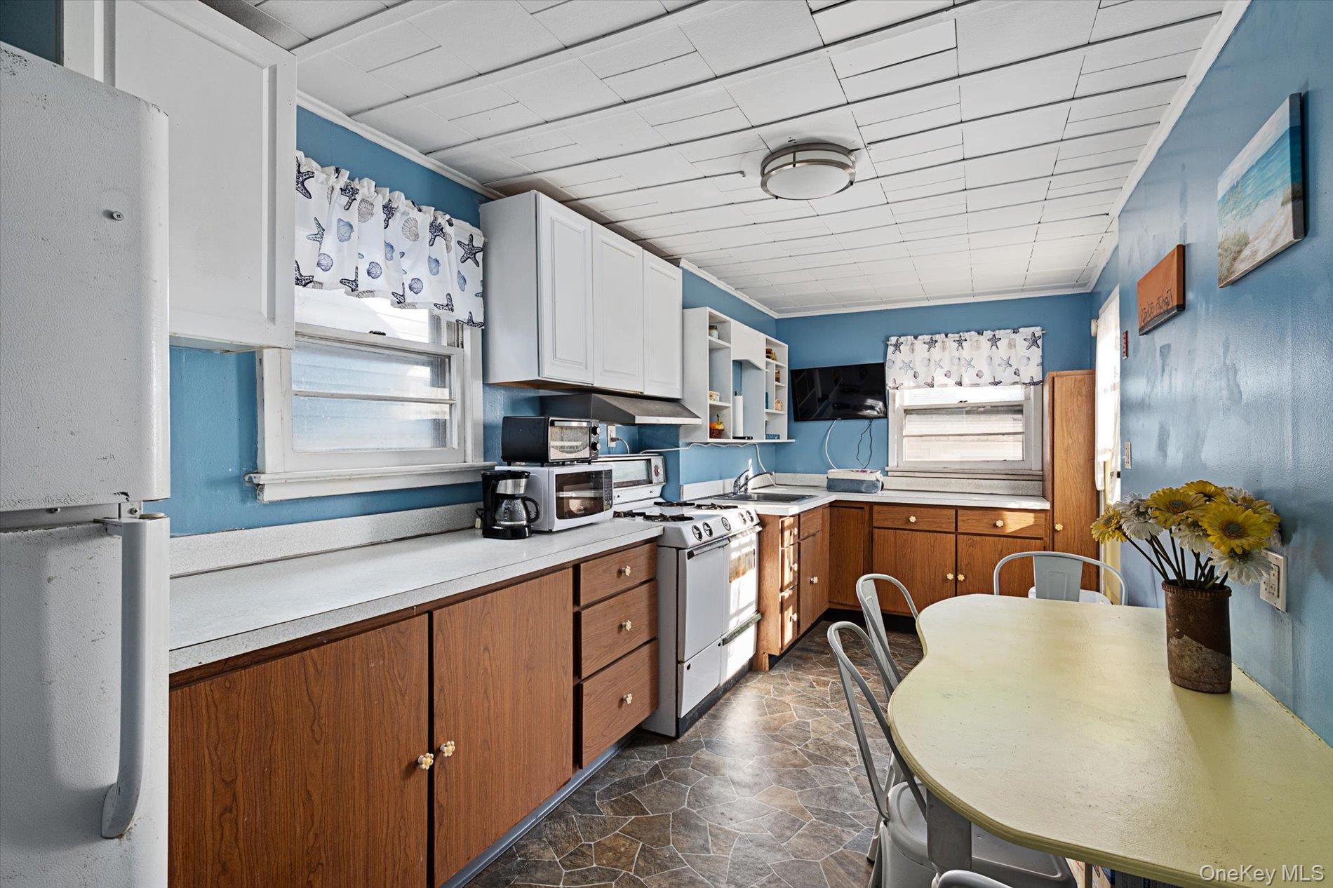 8 July Walk Long Beach, NY 11561 - Photo 9 of 14 a kitchen with stainless steel appliances granite countertop a sink dishwasher a microwave oven with a dining table and chairs with wooden floor