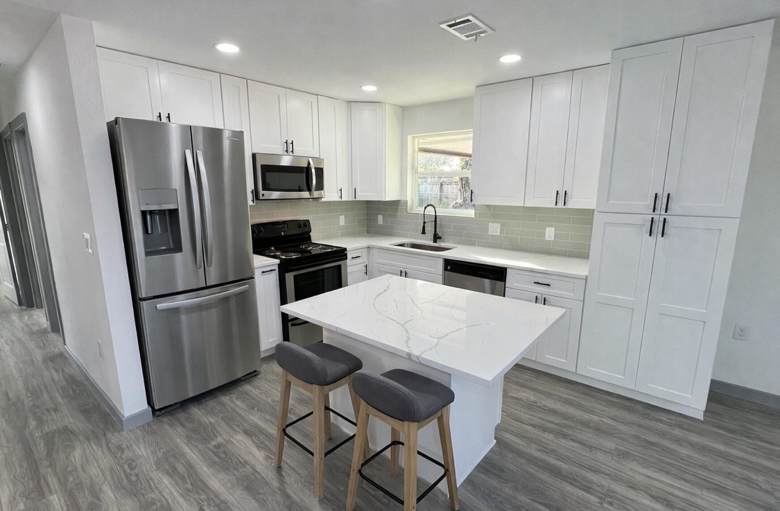8803 Cottage Gate Lane Houston, TX 77088 - Photo 5 of 32 a kitchen with stainless steel appliances a refrigerator stove microwave and cabinets