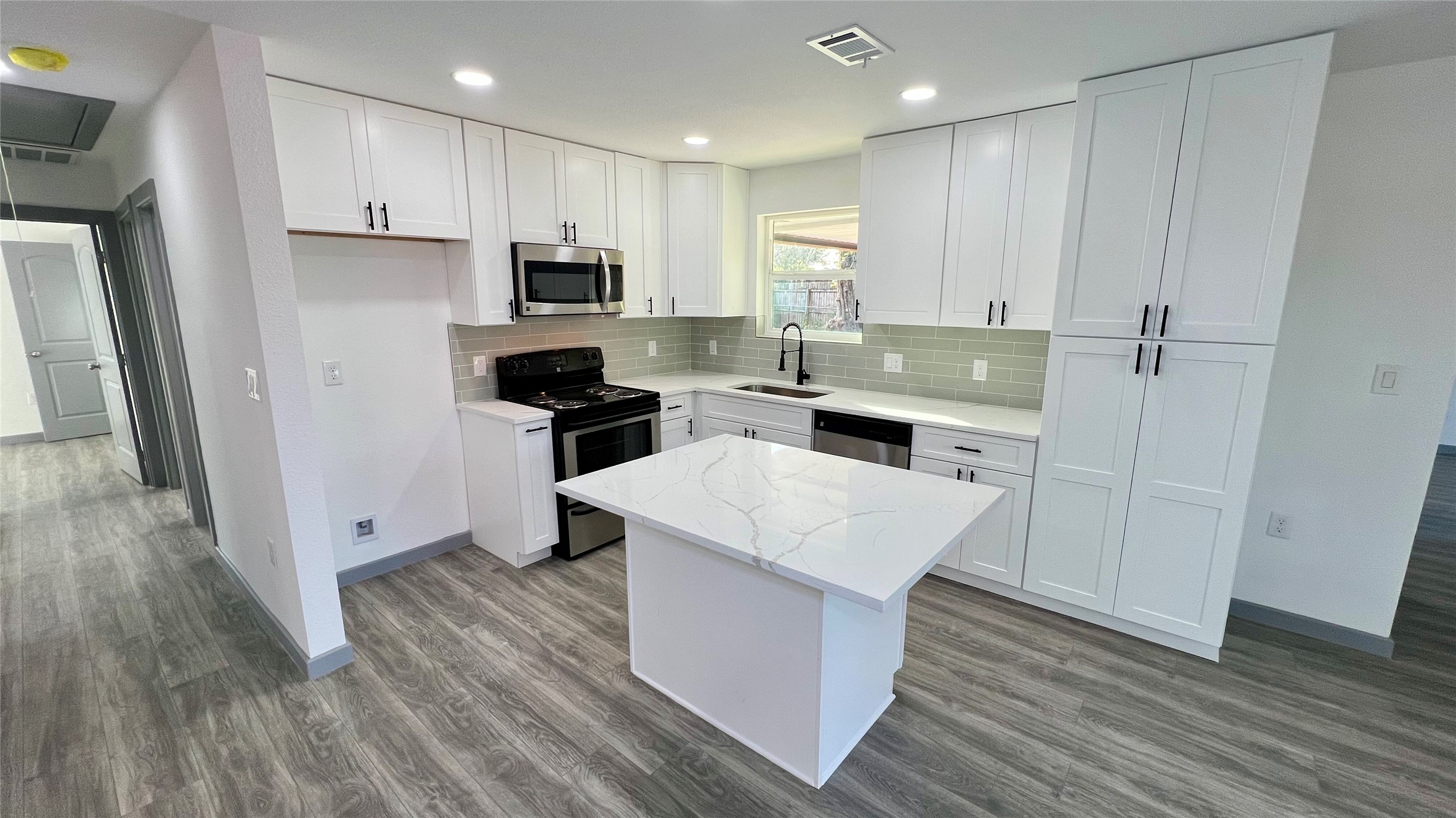 8803 Cottage Gate Lane Houston, TX 77088 - Photo 6 of 32 a kitchen with cabinets wooden floor and stainless steel appliances
