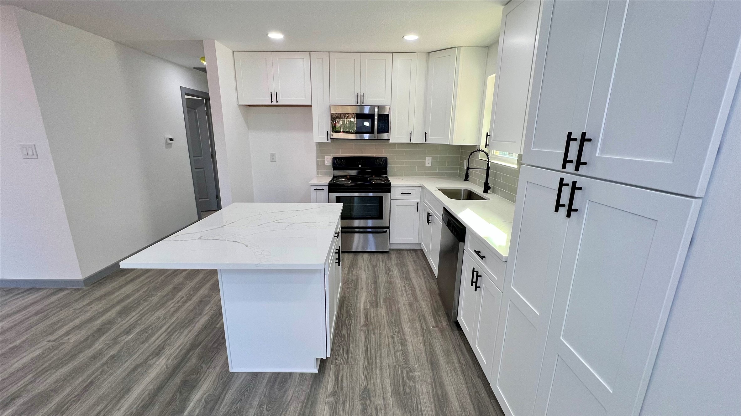 8803 Cottage Gate Lane Houston, TX 77088 - Photo 7 of 32 a kitchen with white cabinets and appliances