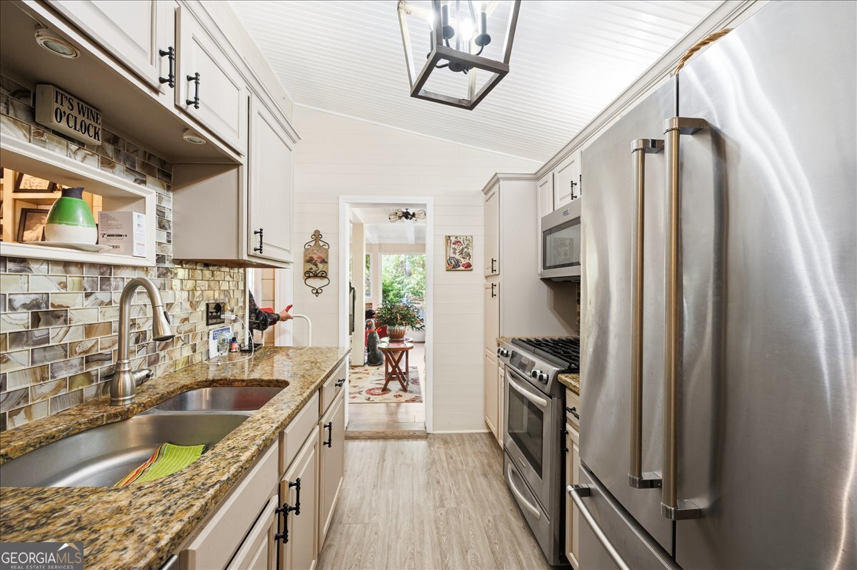 606 Morgan Road Juliette, GA 31046 - Photo 13 of 35 a kitchen with stainless steel appliances granite countertop a sink stove and refrigerator