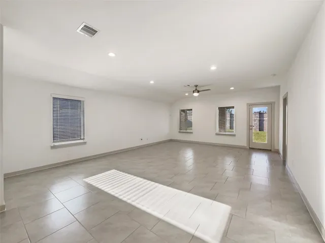 a view of a big room with windows and chandelier fan
