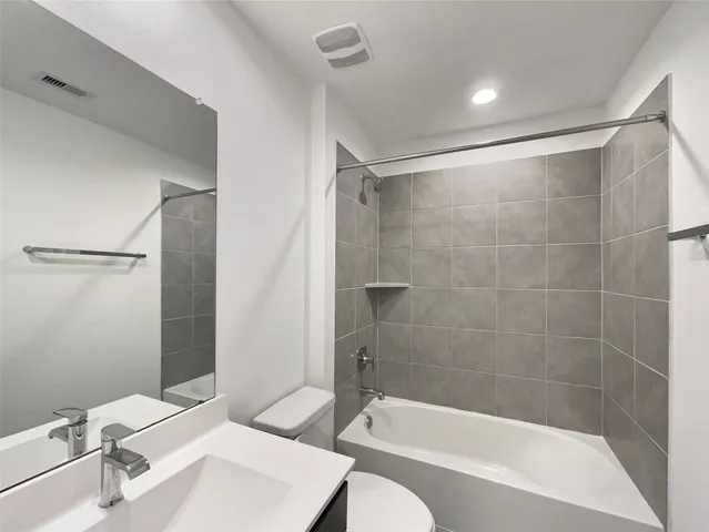 a bathroom with a bathtub shower sink and toilet