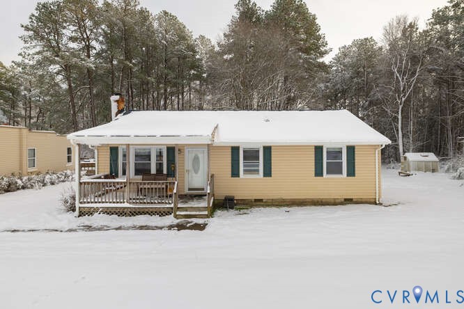 a front view of a house with a yard covered with snow in front of it