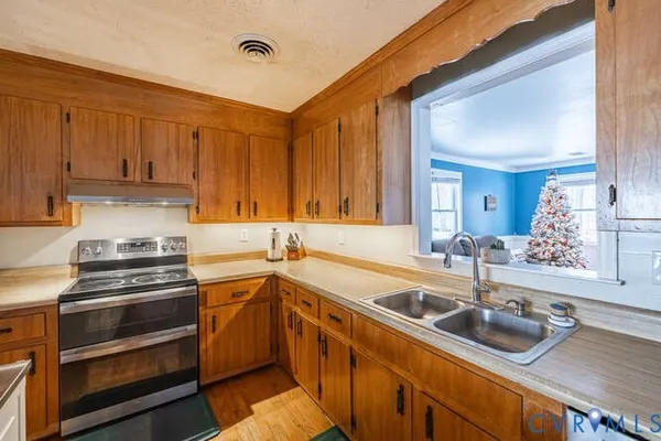 a kitchen with a sink stove top oven and cabinets