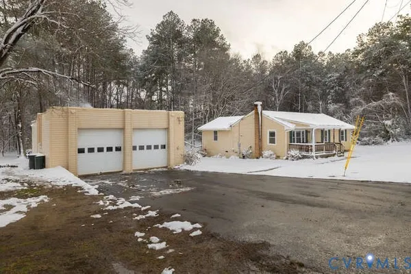 a view of a white house with a large tree in front of it