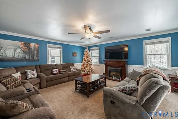 a living room with furniture flat screen tv and a large window
