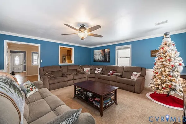 a living room with furniture ceiling fan and a window