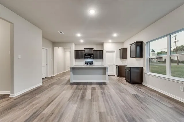 a large kitchen with a large counter top stainless steel appliances and cabinets