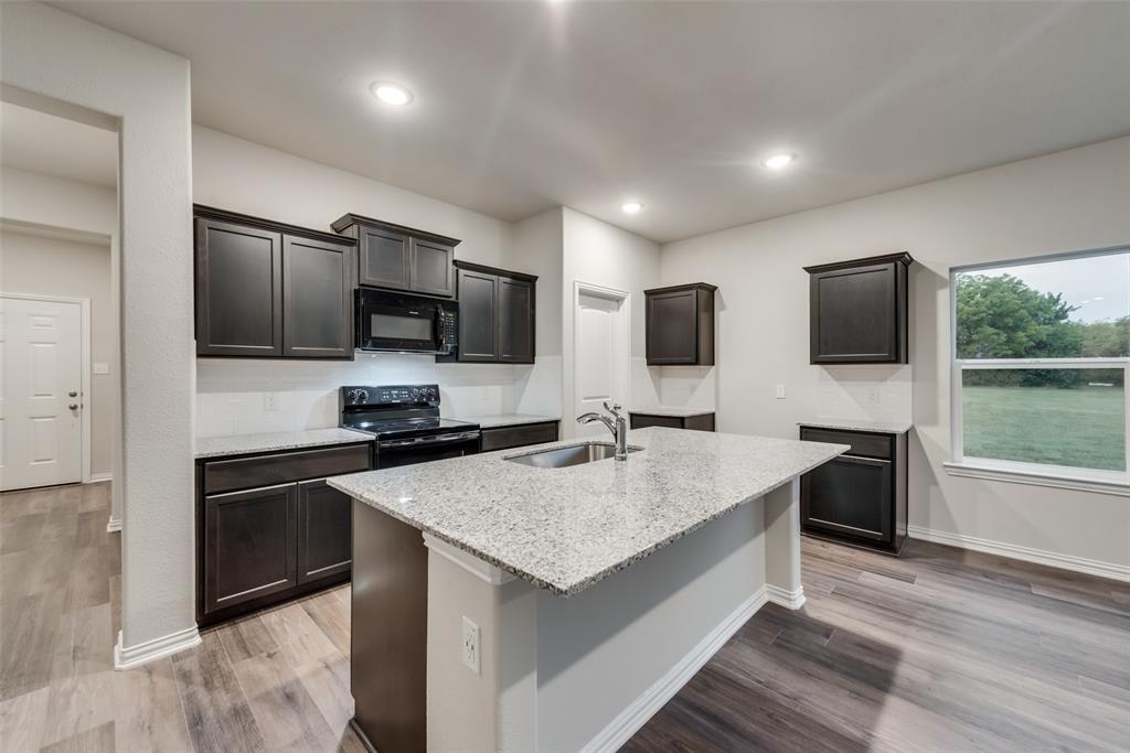 3709 Washington Street Greenville, TX 75401 - Photo 12 of 24 a kitchen with a sink stove and refrigerator