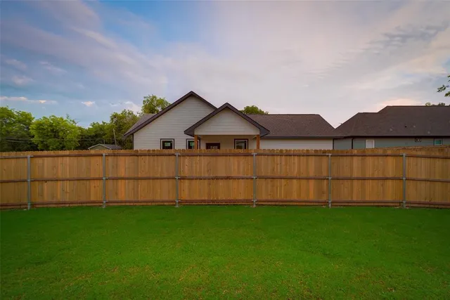 a view of a yard with wooden fence
