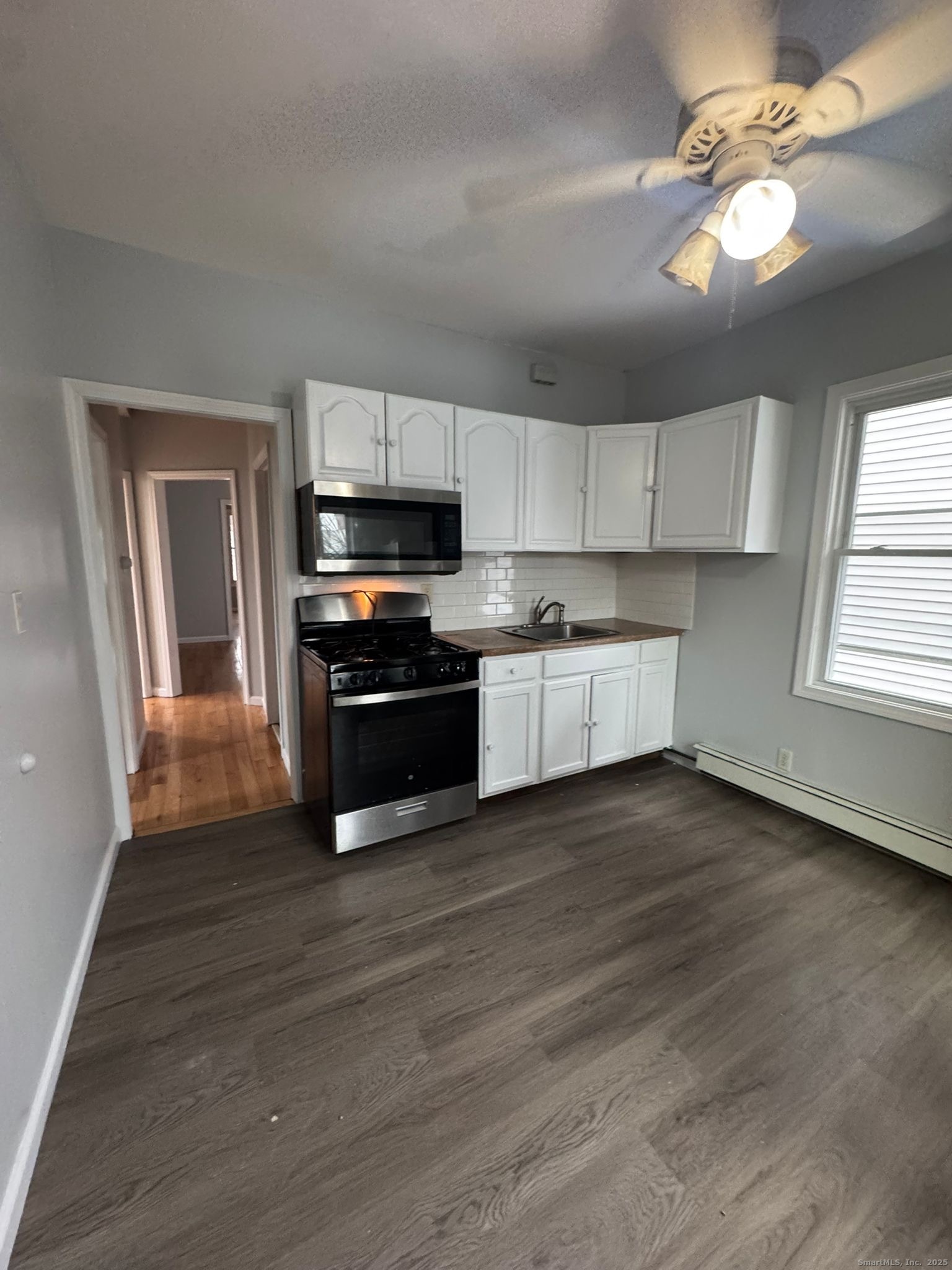 a kitchen with wooden floors and stainless steel appliances