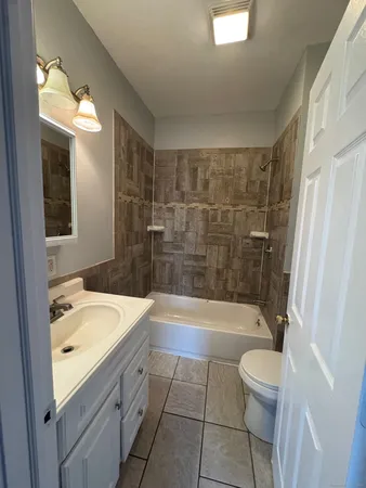 a bathroom with a sink a toilet a mirror and bathtub