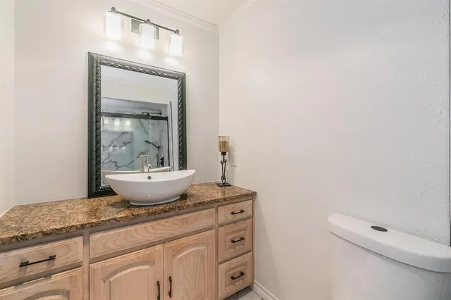 a bathroom with a sink mirror and toilet
