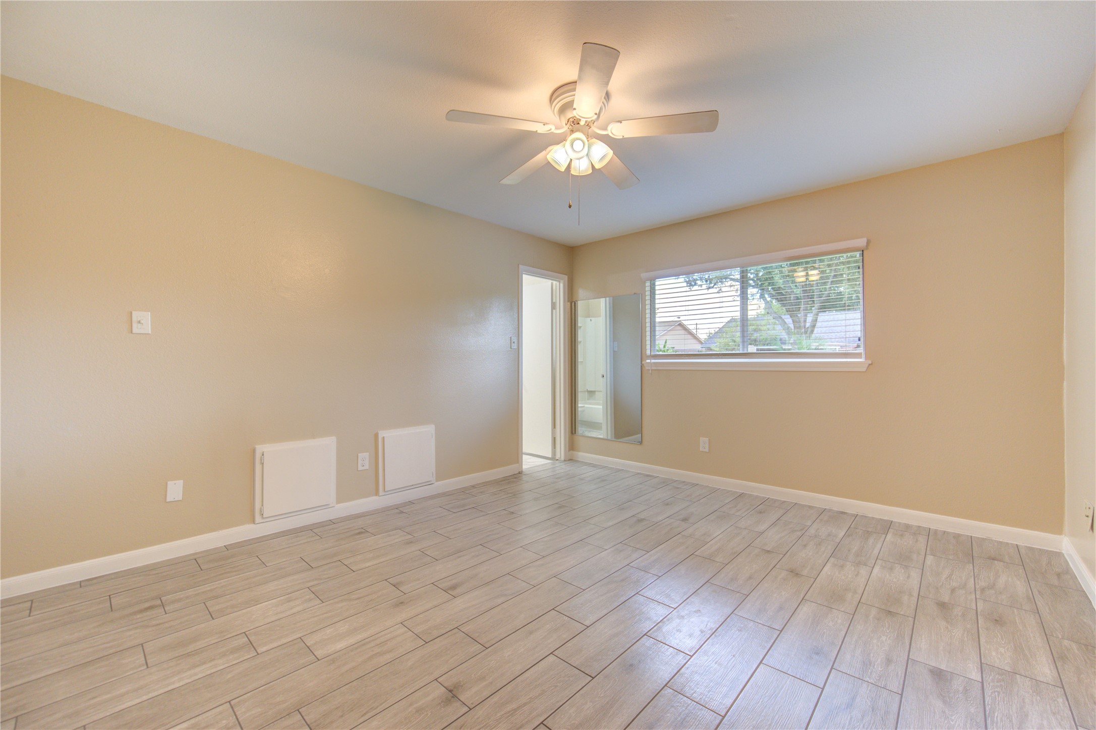 3702 Royal Manor Drive Houston, TX 77082 - Photo 22 of 29 an empty room with wooden floor chandelier fan and windows