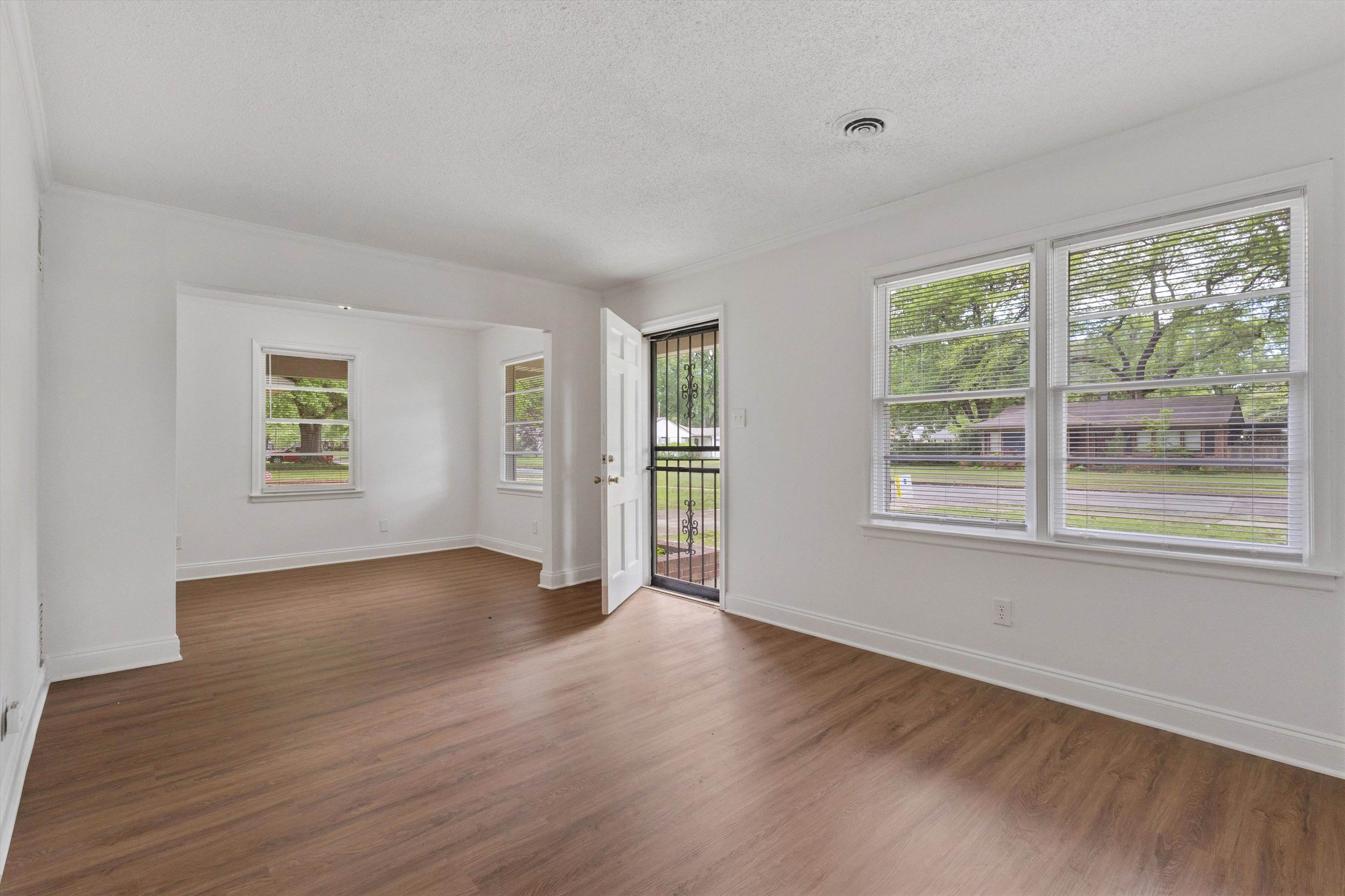 4565 Verne Road Memphis, TN 38117 - Photo 4 of 18 Open-concept room featuring wood-finish flooring, white baseboards, and multiple windows with horizontal blinds