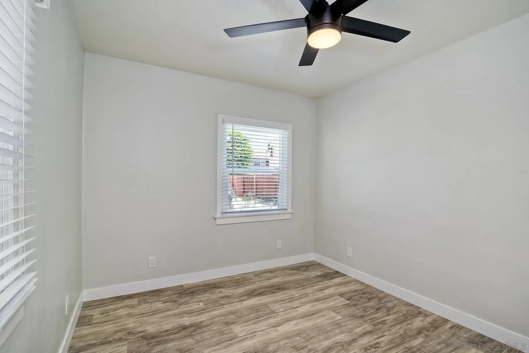 4685 Hamilton Street San Diego, CA 92116 - Photo 15 of 37 a view of empty room with wooden floor and fan