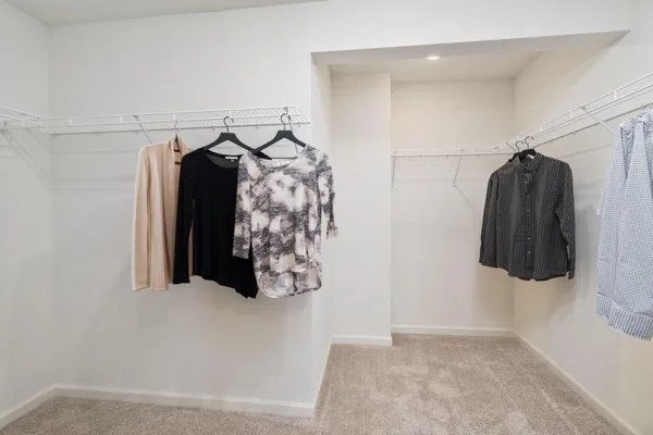 a view of walk in closet with clothes