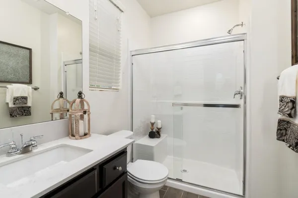 a bathroom with a granite countertop sink toilet and shower