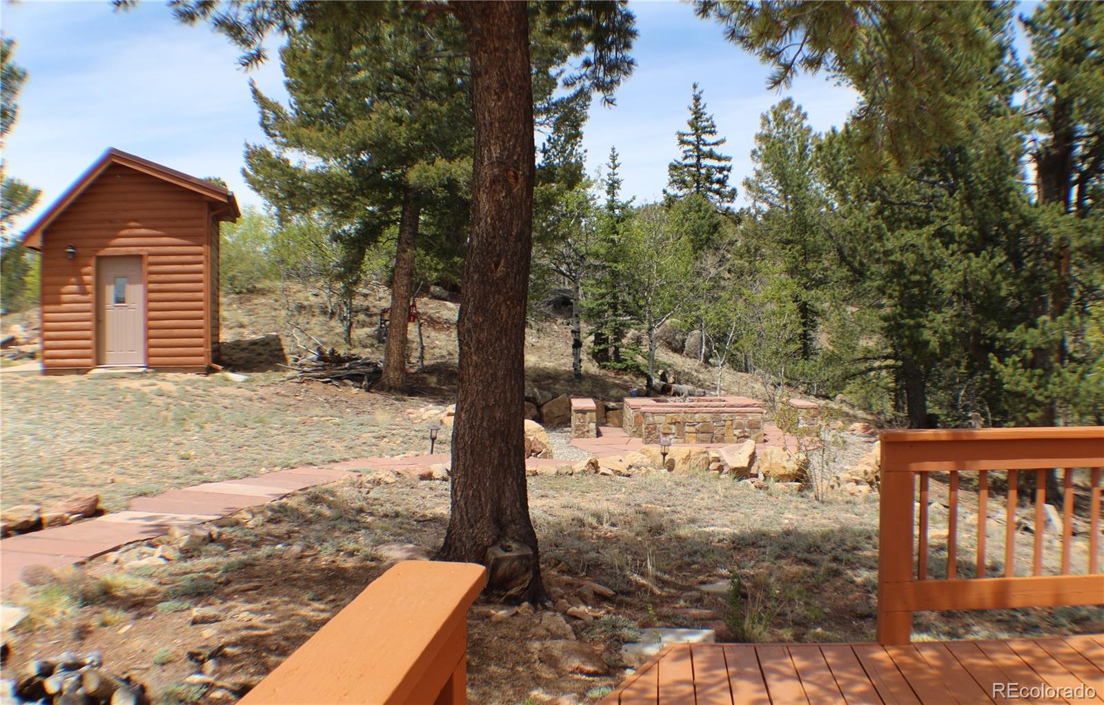8221 Remington Road Como, CO 80432 - Photo 8 of 49 a backyard of a house with large trees and wooden fence