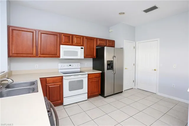 a kitchen with stainless steel appliances granite countertop a stove a sink dishwasher and a refrigerator