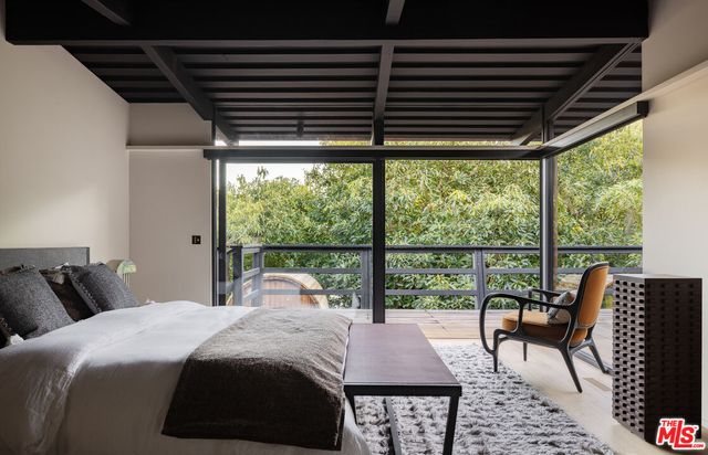 a bedroom with bed and a large window