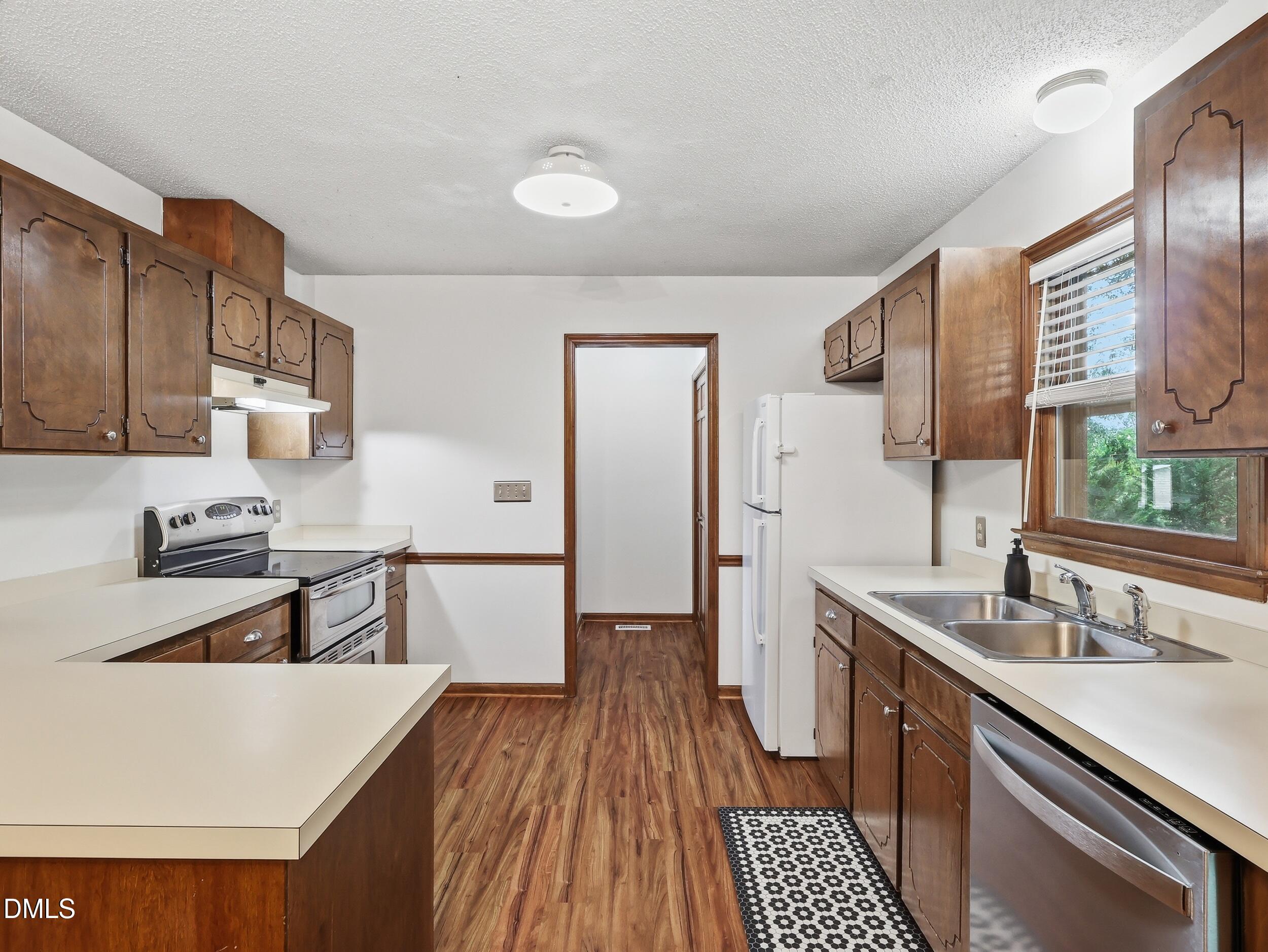 517 Lake Glad Road Wendell, NC 27591 - Photo 14 of 36 a kitchen with a sink a stove a refrigerator and wooden cabinets