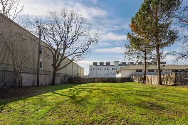 a large house with a big yard and large trees