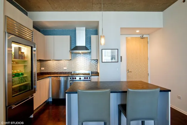 a kitchen with stainless steel appliances granite countertop a stove a sink and a refrigerator