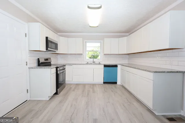 a kitchen with a white cabinets and window
