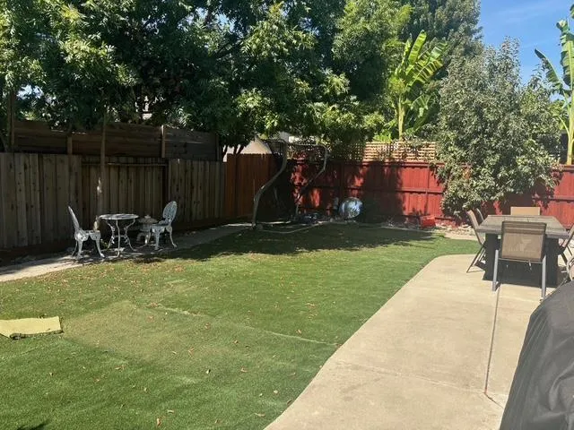 a backyard of a house with table and chairs