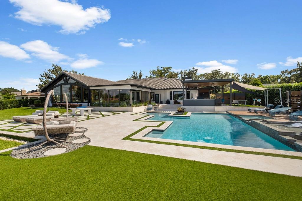 2844 Marquesas Court Windermere, FL 34786 - Photo 66 of 75 a view of a swimming pool with lawn chairs with plants