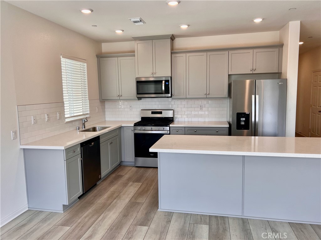 19549 Sunkissed Rdg Drive Riverside, CA 92507 - Photo 2 of 17 a kitchen with kitchen island granite countertop a sink a counter top space stainless steel appliances and cabinets