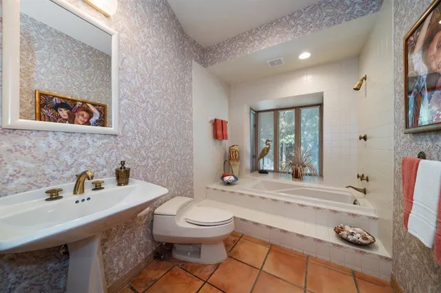 a bathroom with a sink a toilet and mirror