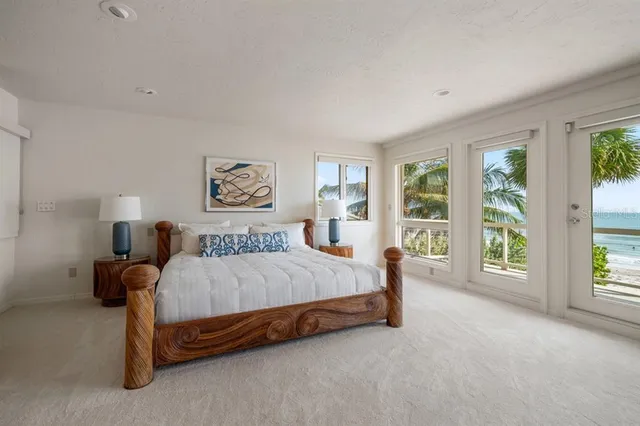 a bed sitting in a spacious bedroom next to a large window