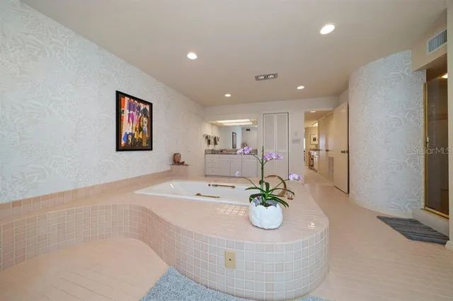 a bedroom with a large bed and a chandelier