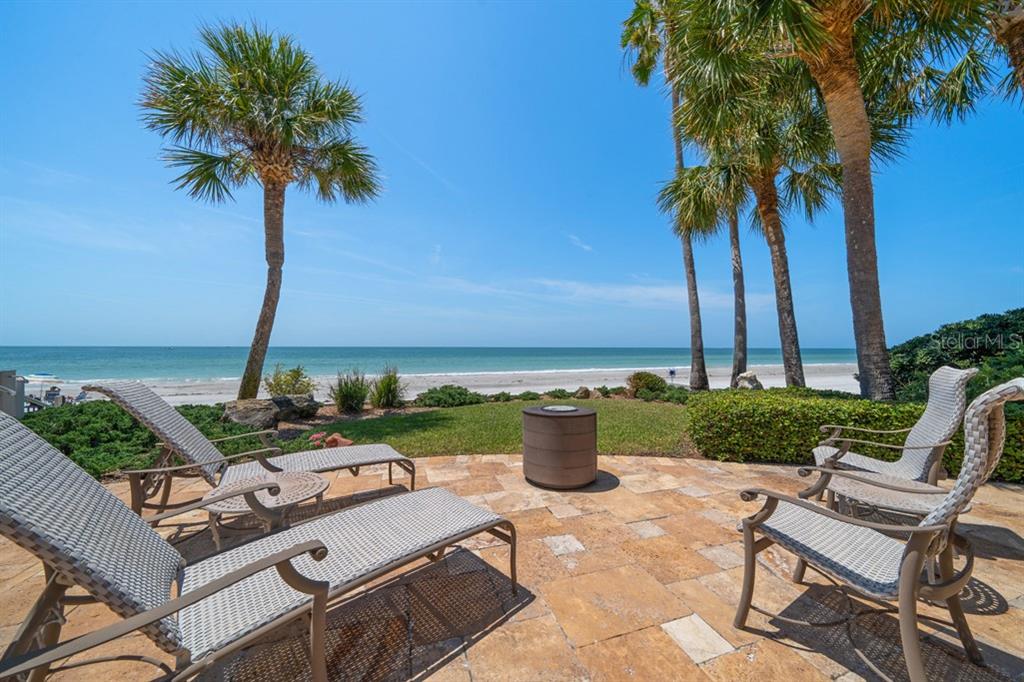 16000 Gulf Boulevard Redington Beach, FL 33708 - Photo 36 of 47 a view of a patio with table and chairs potted plants and palm tree