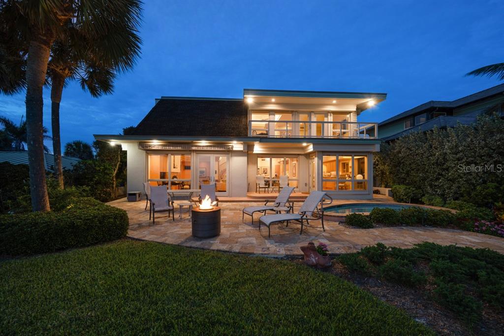 16000 Gulf Boulevard Redington Beach, FL 33708 - Photo 46 of 47 a view of a patio with table and chairs potted plants and palm trees