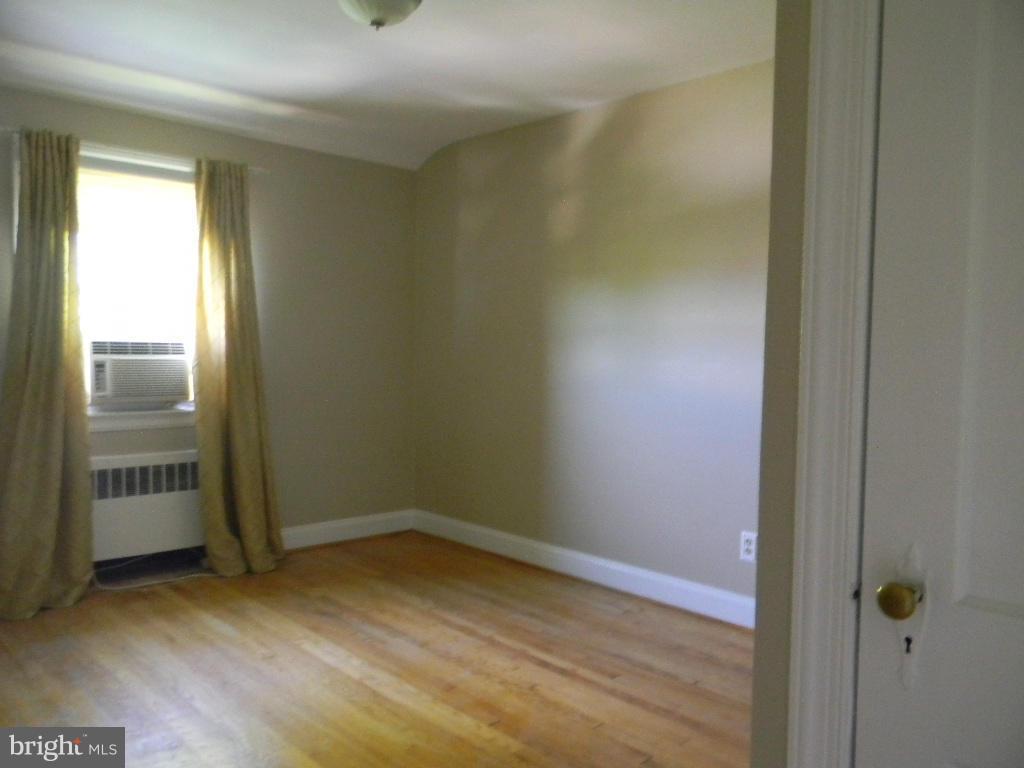 3923 Rexmere Road Baltimore, MD 21218 - Photo 14 of 21 an empty room with wooden floor and windows