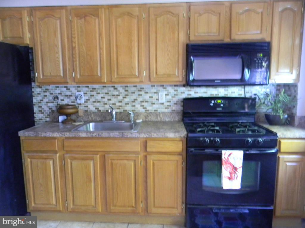 3923 Rexmere Road Baltimore, MD 21218 - Photo 8 of 21 a kitchen with stainless steel appliances granite countertop a stove and a microwave