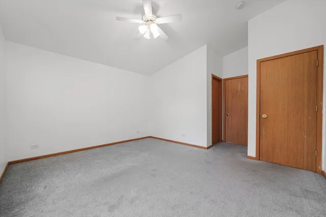 an empty room with a ceiling fan and a window