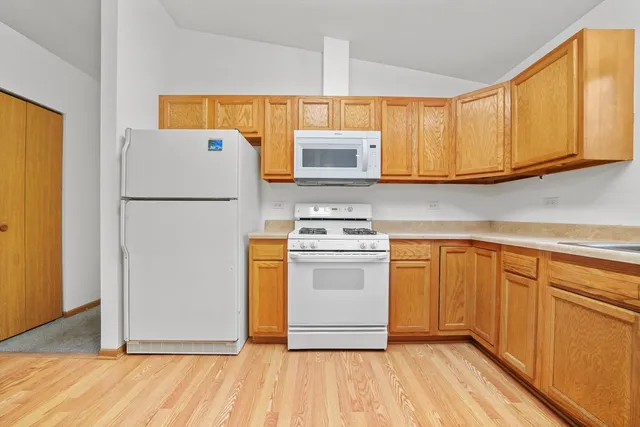 a kitchen with a refrigerator sink and cabinets